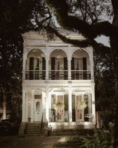 a large white house with lots of windows and balconies on the second floor