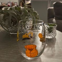 two glass vases sitting on top of a table with succulents in them