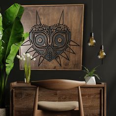 a wooden table with a plant in front of it and an art piece hanging on the wall