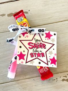 a candy bar wrapped in paper and tied to a star shaped gift tag with the words you shine like a star on it