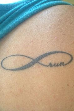 the back of a woman's shoulder with an infinite sign tattoo on her left arm