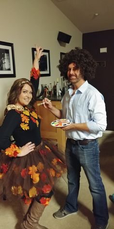 a man standing next to a woman in a dress with flowers on it's skirt