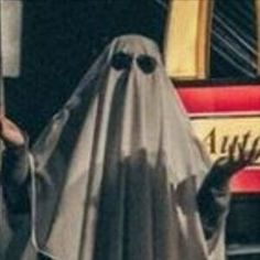 a man dressed as a ghost holding a sign