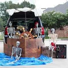 a trunk with skeletons sitting in it next to a car