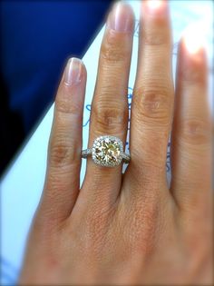 a woman's hand with a diamond ring on top of her finger and an engagement band