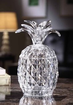 a crystal pineapple shaped vase sitting on a table next to a stack of books