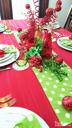 the table is set with red and green decorations