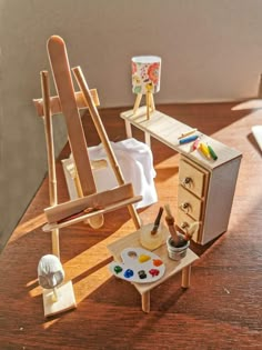 an artist's easel and paintbrush on a wooden table