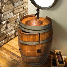 a wooden barrel sitting on top of a hard wood floor next to a round mirror