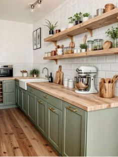 a kitchen with green cabinets and wooden counters