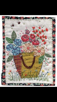 an embroidered bag with flowers and leaves on it