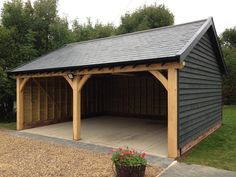 a wooden garage with a black roof