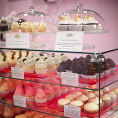 a display case filled with lots of different types of cupcakes and muffins