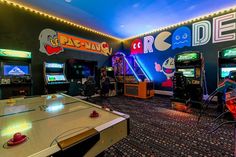 a room with arcade machines and video games on the walls, along with other gaming equipment