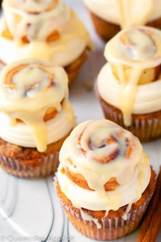 cinnamon roll cupcakes with icing and cinnamon sticks