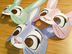 three bunny masks sitting on top of a wooden table