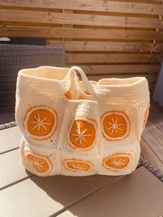 an orange crocheted bag sitting on top of a wooden table