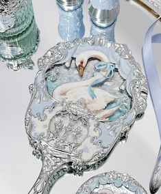 a glass plate with a swan on it next to some water bottles and silverware