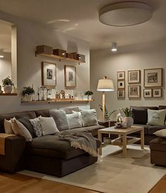 a living room filled with lots of furniture next to a wall mounted shelf full of pictures