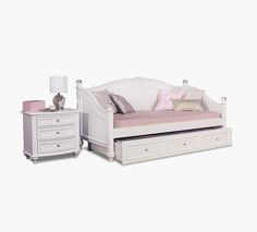 a white daybed with drawers underneath it next to a night stand and nightstand table