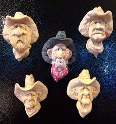 four clay heads with hats and beards on them