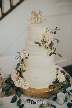 a wedding cake with white flowers and greenery