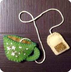 two green and white purses sitting on top of a wooden table next to each other