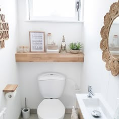 a white toilet sitting in a bathroom next to a sink