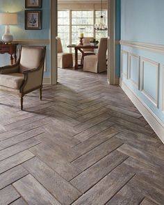 a living room with blue walls and wood flooring in the center is a dining area