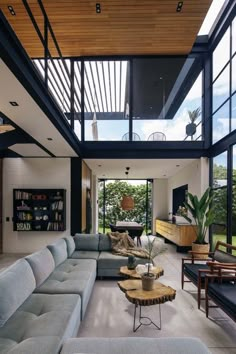 a living room filled with lots of furniture and large glass windows on top of it