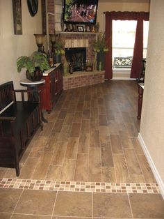 a living room with tile flooring and a tv mounted on the wall above a fireplace