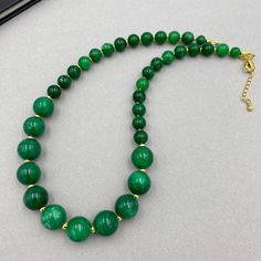 This green jade bead gemstone choker features deep green beads in a sophisticated statement design. Perfect for layering or wearing solo, this elegant necklace is a timeless accessory that makes a thoughtful and stylish gift for her. This is a handcrafted necklace, uniquely designed with attention to every detail. - Necklace length is 16" long plus additional 2 inch extender chain. Made from dyed natural jade 8 and 10 mm beads. - 24K gold plated extender chain - clasp is 24K gold plated lobster claw This necklace would make the PERFECT GIFT for you, or for your loved ones. Its timeless design and superior craftsmanship ensure it will be cherished by whoever receives it. Comes beautifully packaged in a gift box!  Thank you for your visit!  Halloween, Halloween jewelry, Fall Autumn necklace, Jade Bead Necklace, Autumn Necklace, Gemstone Choker, Christmas Necklace, Necklace Layering, Jade Necklace, Green Beads, Beaded Statement Necklace, Elegant Necklace