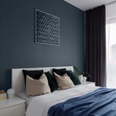 a bedroom with dark blue walls and white bedding, black drapes on the windowsill