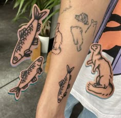 a person with some tattoos on their arm and one is holding a fish in the other hand