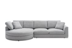 a grey sectional couch with pillows on the top and bottom corner, in front of a white background