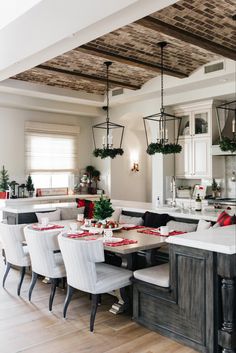 a dining room table with white chairs and red napkins on the placemats