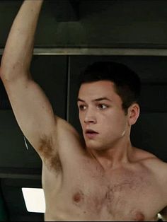 a shirtless young man holding his arm up in the air