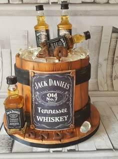 a cake made to look like a barrel with whiskey bottles on top and ice in the bottom