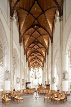 the inside of a large church with wooden chairs and tables set up for an event