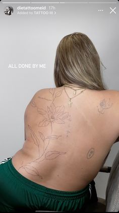 the back of a woman's body with tattoos on it