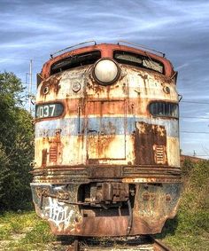 an old rusty train sitting on the tracks