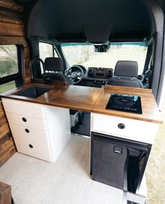 the interior of a camper with an oven and sink