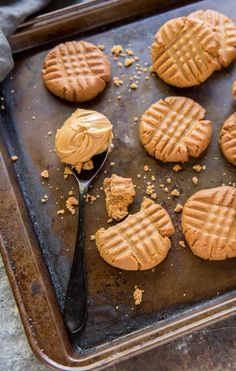 peanut butter cookies on a baking sheet with a spoon