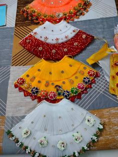 four different types of dresses are on display in a room with wooden flooring and colorful fabrics