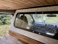 the interior of a vehicle with wood paneling on the floor and windows in it