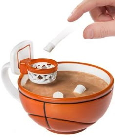 an orange and white basketball cup with a hand reaching for it