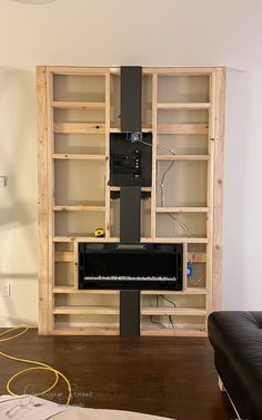 a living room filled with furniture and bookshelves next to a wall mounted tv