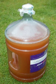 a gallon of liquid sitting in the grass