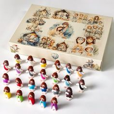 a group of small figurines sitting in front of a box with pictures on it