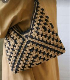 a crocheted purse is being held by a woman